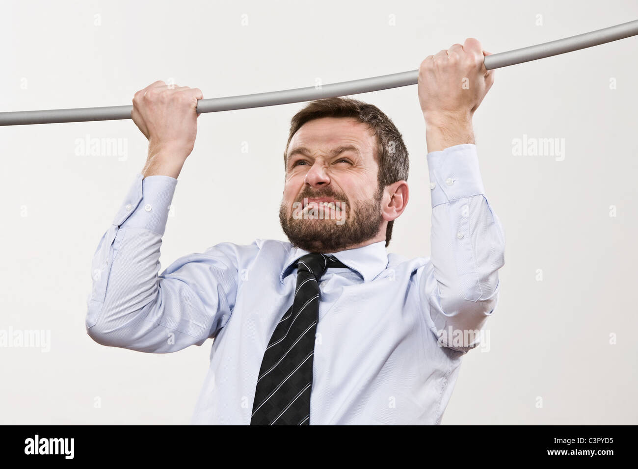 Businessman doing pull-ups, close-up Stock Photo