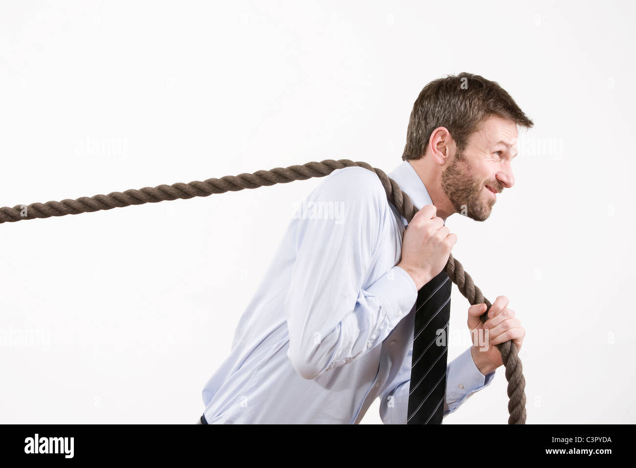 Businessman pulling rope, side view Stock Photo