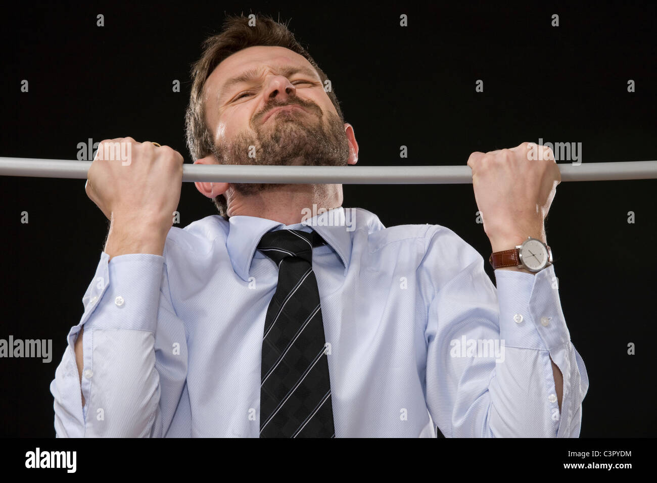 Businessman doing pull-ups, close-up Stock Photo