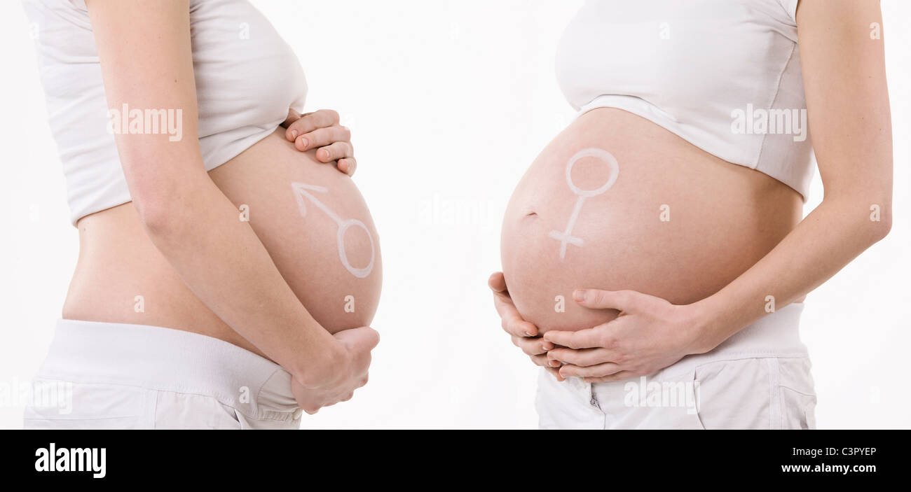 Male and female symbol drawn on a pregnant women's belly, mid section Stock Photo
