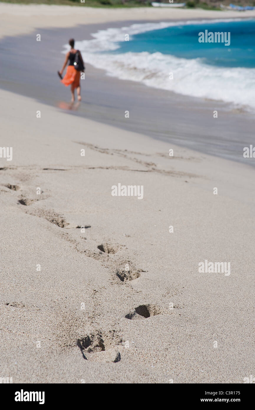 Asia, Indonesia, Lombok, Mature woman walking on sandy beach Stock Photo