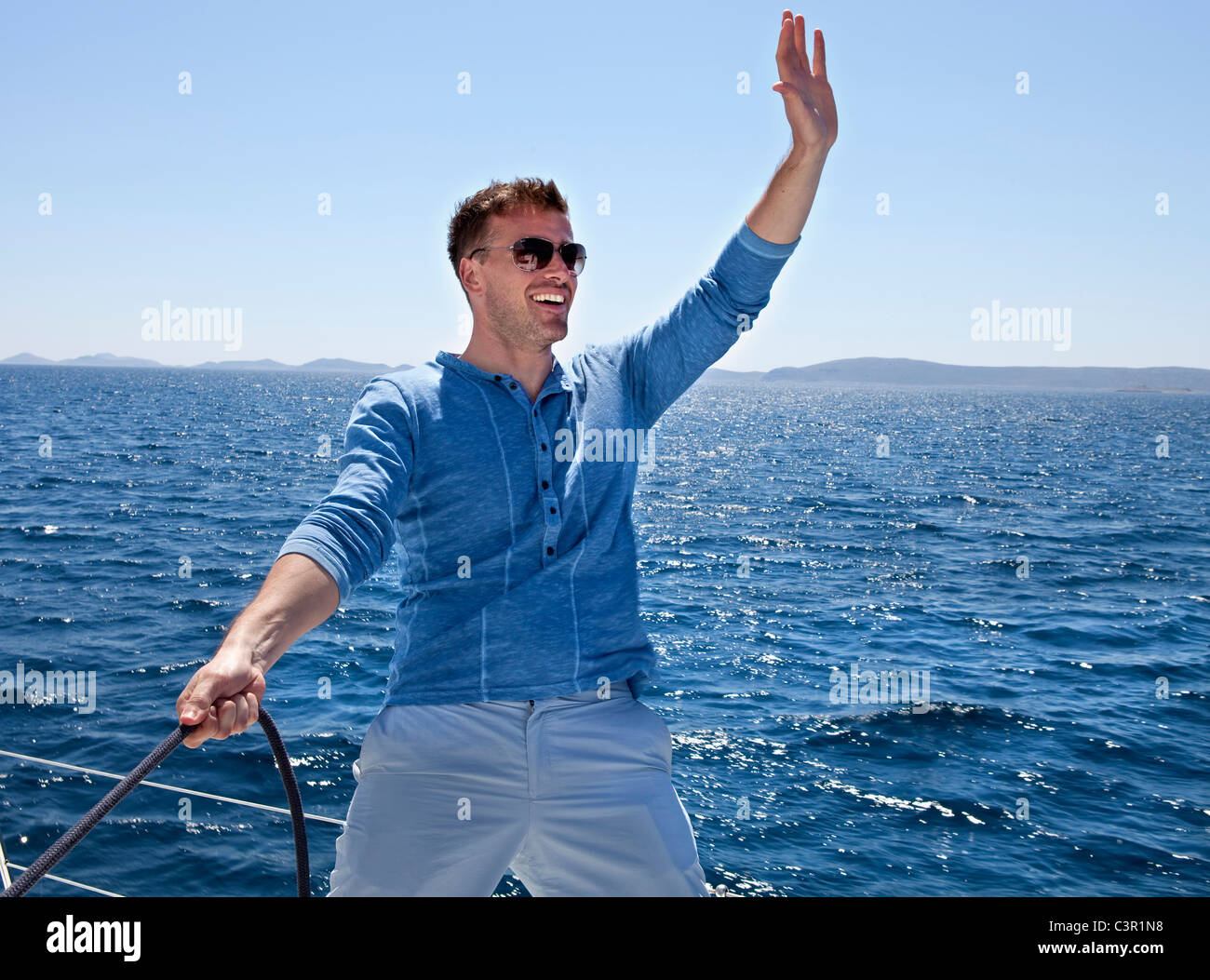 Young man waving from sail boat hires stock photography and images Alamy