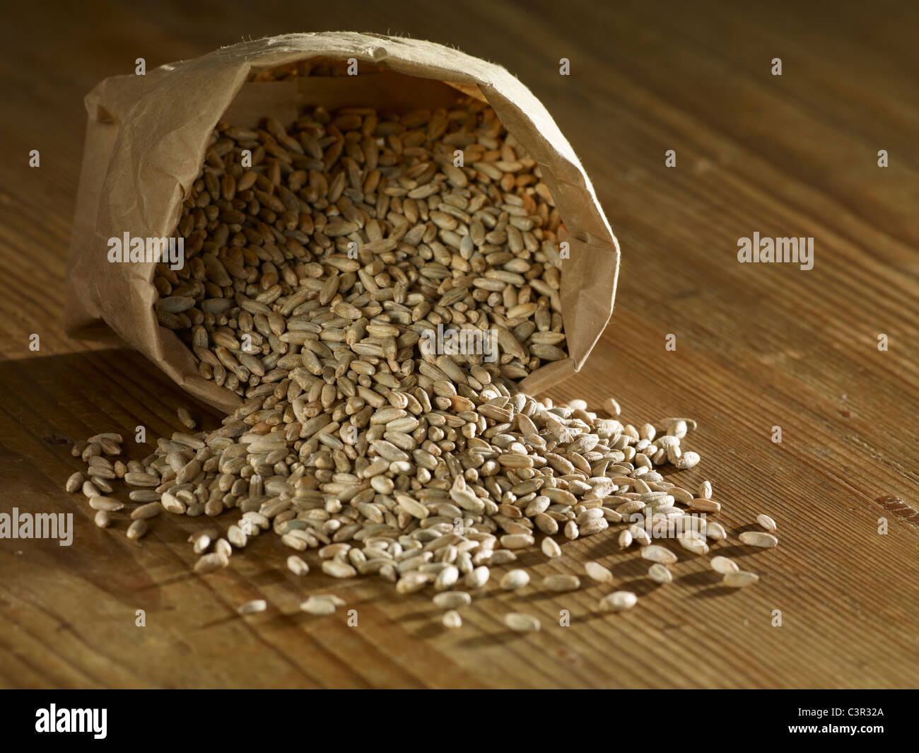 Rye grains spilling on wooden surface Stock Photo - Alamy