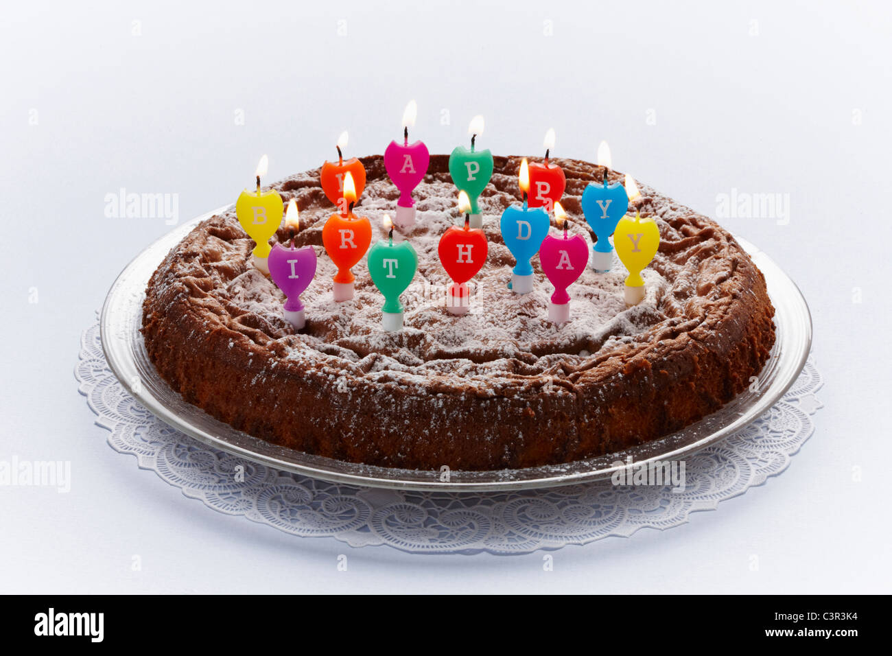 Birthday cake with burning candles on white background Stock Photo - Alamy