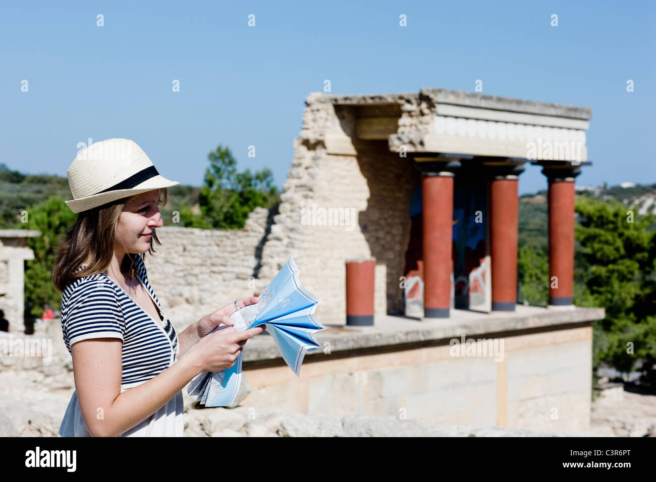 woman looking and holding a map in front of temple Stock Photo
