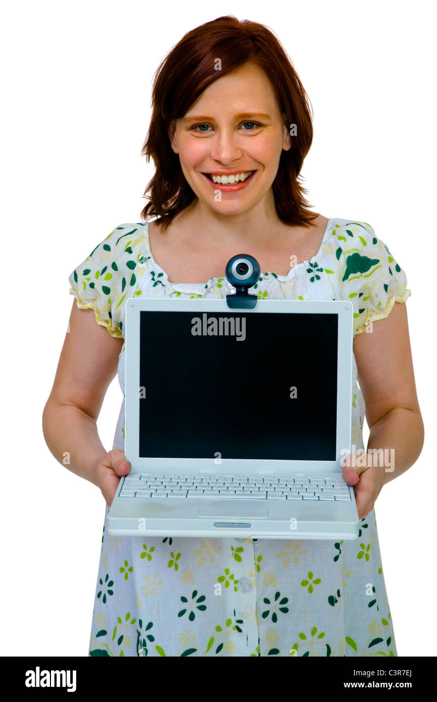 Portrait of a woman showing a laptop and smiling isolated over white ...