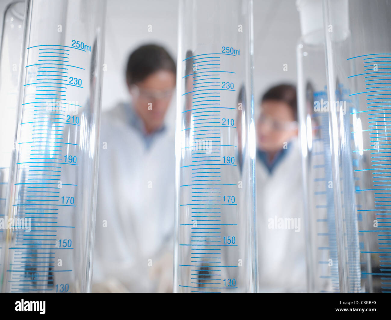 Scientists behind laboratory equipment Stock Photo