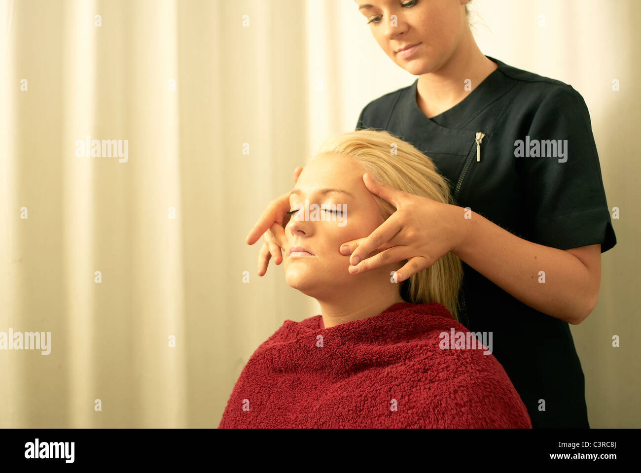 Beautician giving face massage Stock Photo