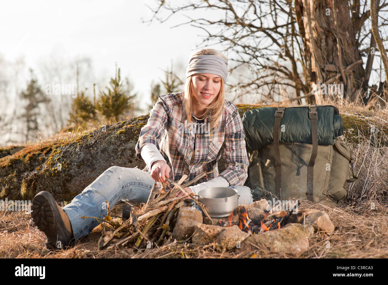 Campfire hiking woman with backpack cook in countryside Stock Photo Alamy