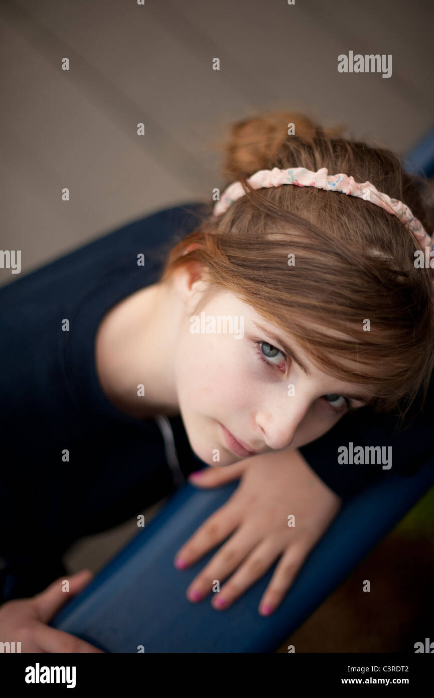 A 12-13 year teenage old girl, outdoors UK, looking up Stock Photo