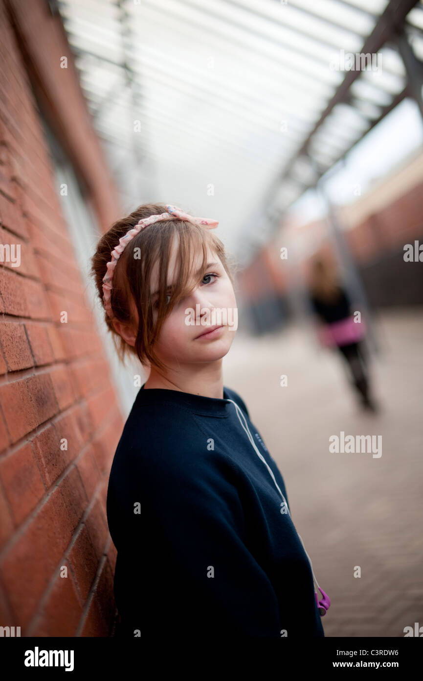 A 12-13 year teenage old girl, alone outdoors UK Stock Photo