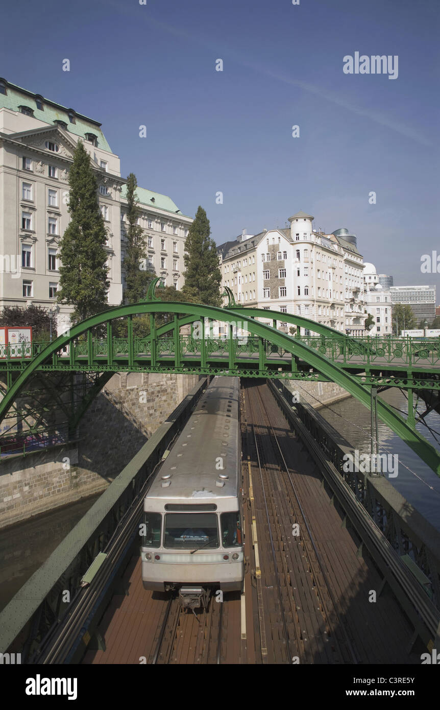Austria, Vienna, Danube channel, Metro rail passing under bridge with city in background Stock Photo