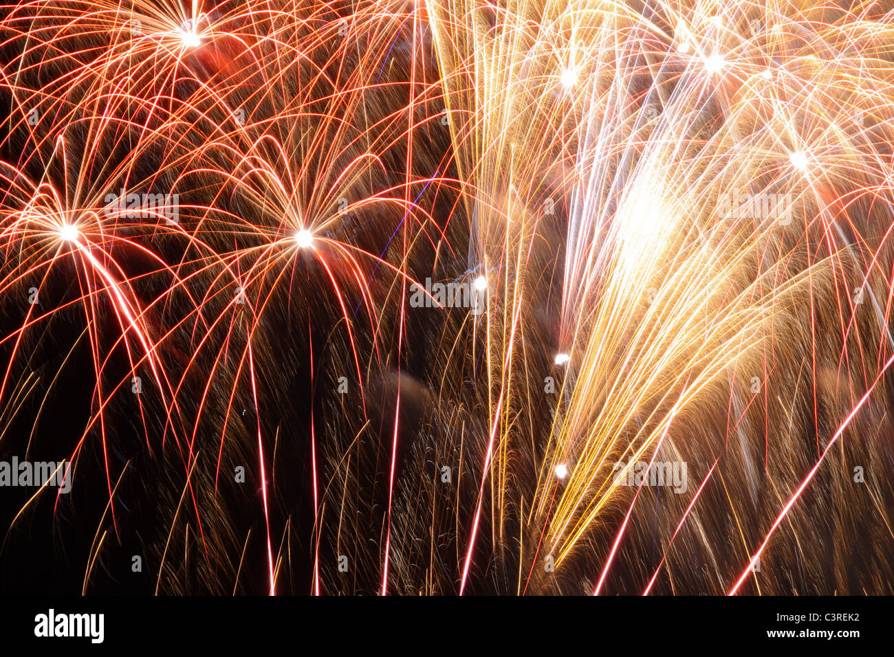 Fireworks exploding against dark night sky Stock Photo