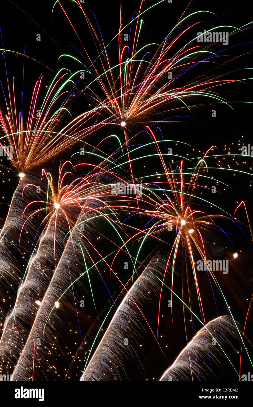 Fireworks exploding against dark night sky Stock Photo