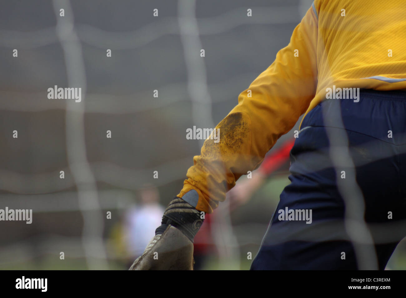 Goalkeeper playing football in front of football net Stock Photo