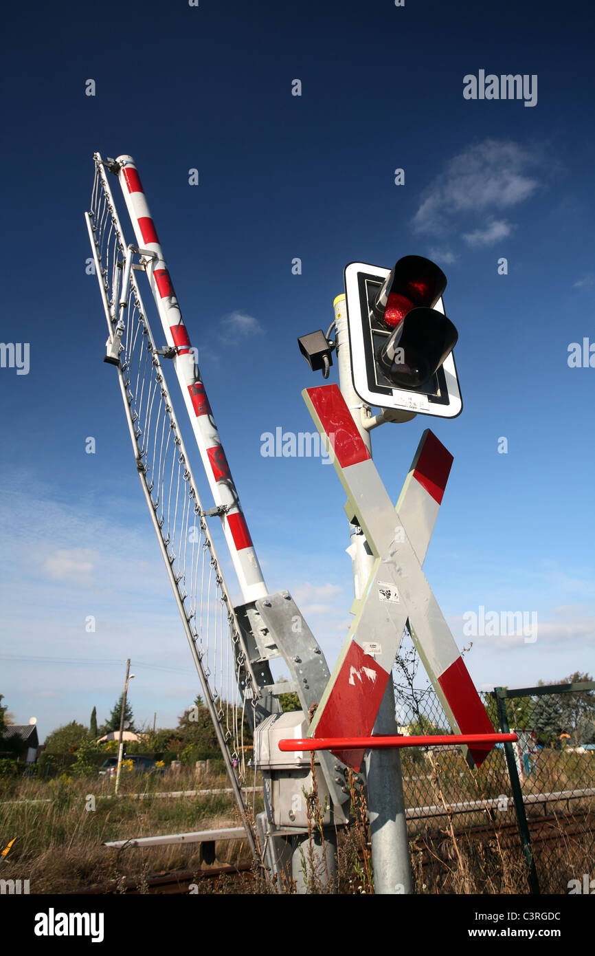 St Andrew's cross with warning lights and barriers at a railway crossing Stock Photo