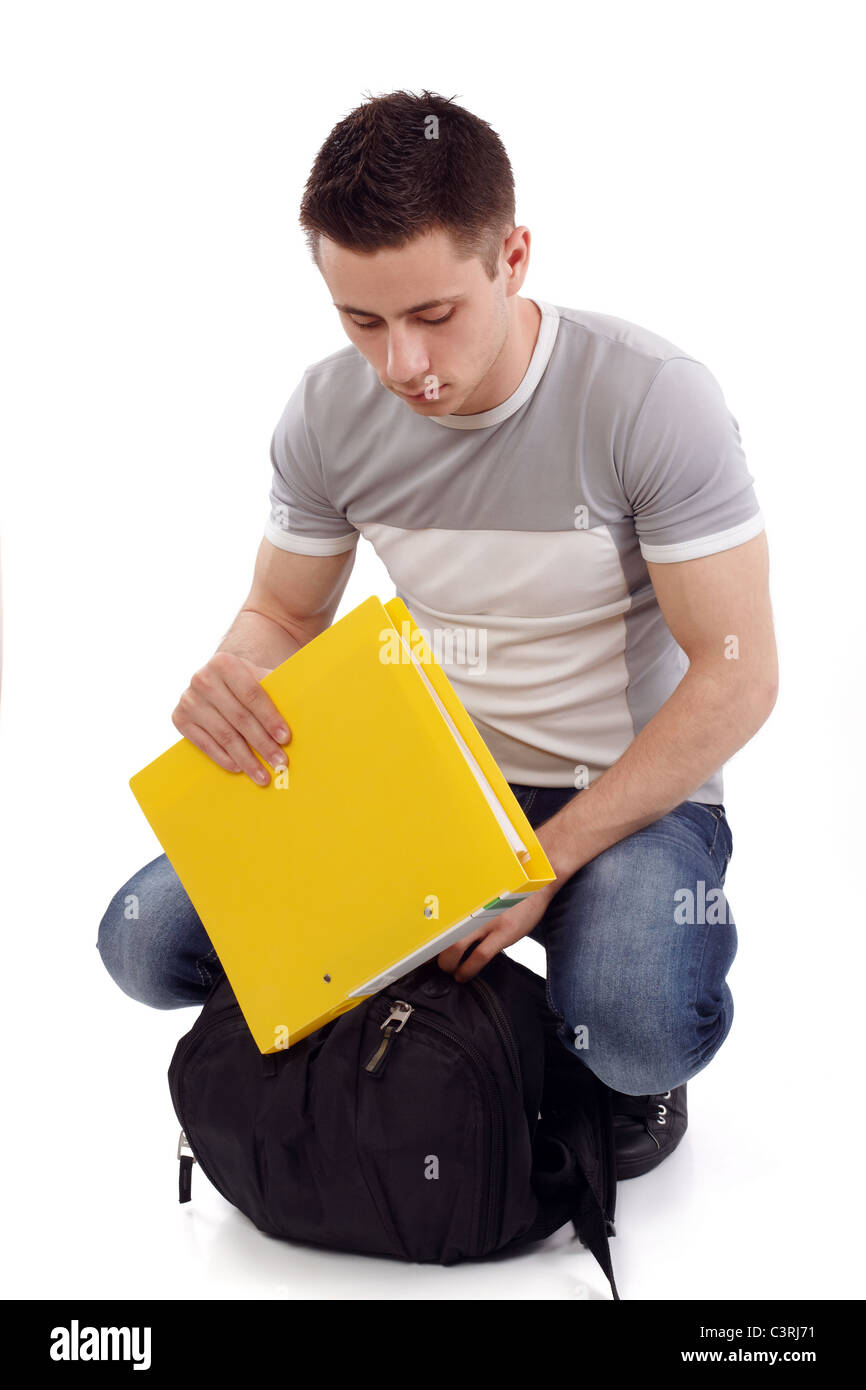 Young student packing his yellow notebook man down Stock Photo