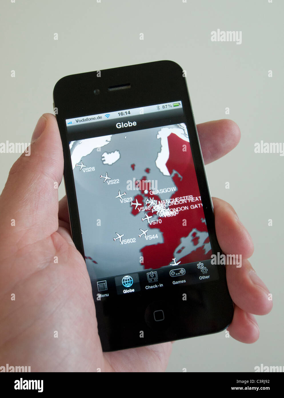 Man using Virgin Airlines flight tracker app on an iPhone 4G smart phone Stock Photo