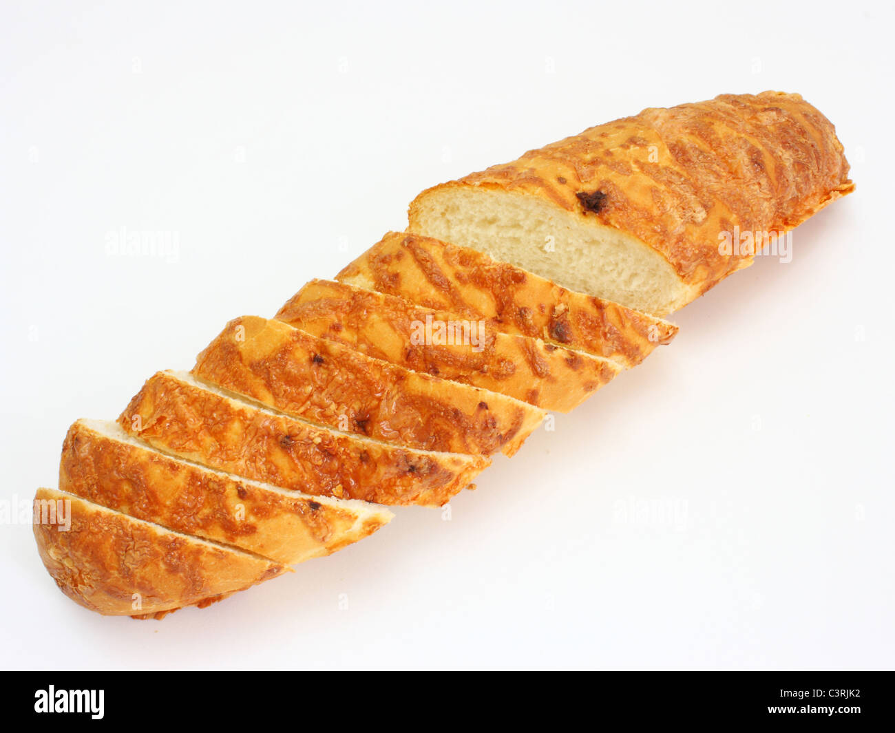 The ruddy long loaf of bread is strewed by cheese isolated on a white background Stock Photo