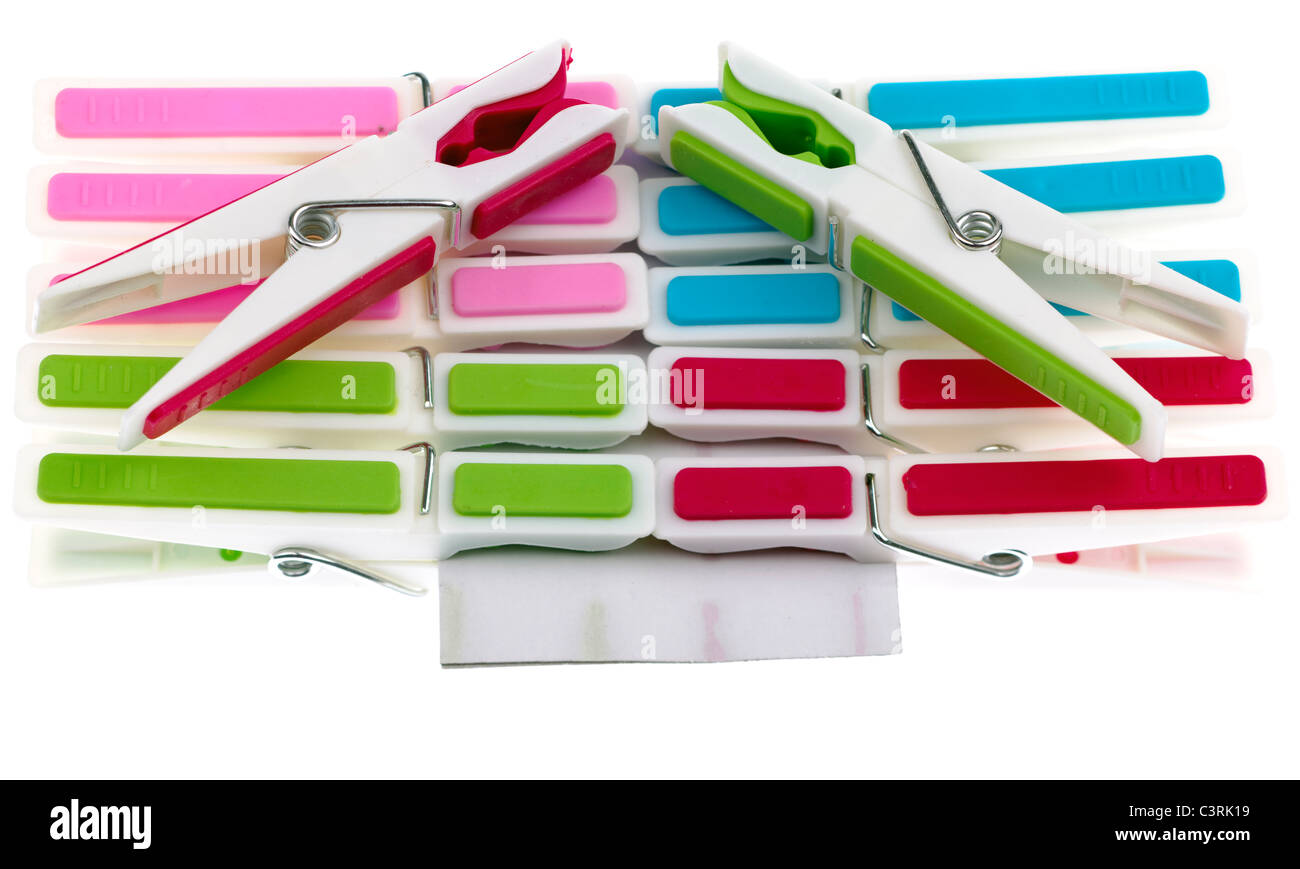 Pile of coloured plastic clothes pegs clipped onto cardboard Stock Photo