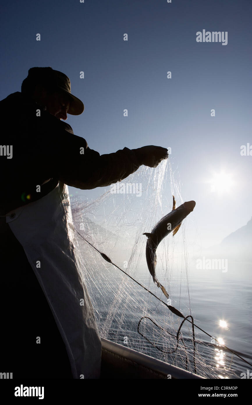 Austria, Mondsee, Fisherman caught a fish in fishing net Stock Photo