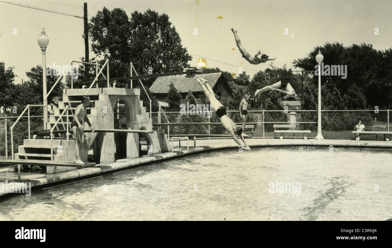 three divers diving from board at public swimming pool 1930s great depression Stock Photo