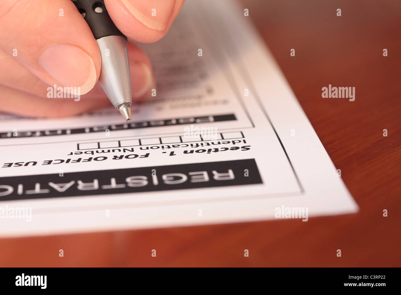 Hand with Pen Completing Form On Table Closeup Stock Photo - Alamy