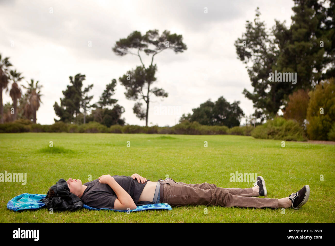 Caucasian man laying in grass in park Stock Photo