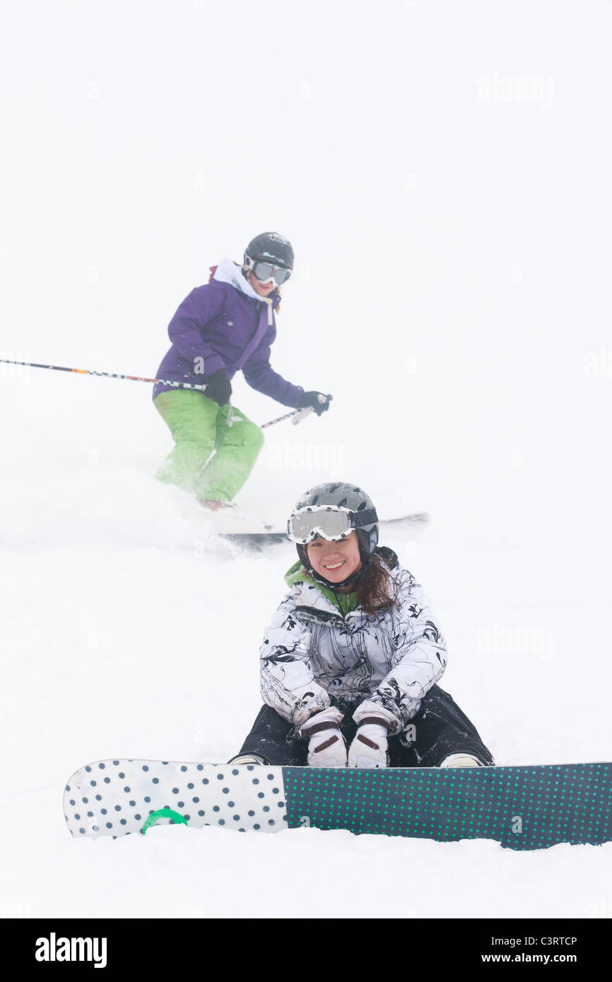 Skier and snowboarder on ski slope Stock Photo