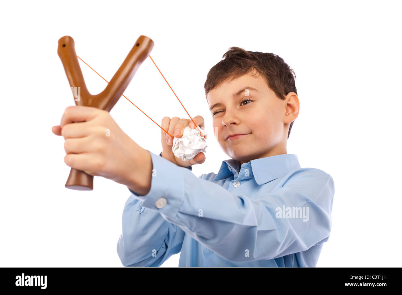 Portrait of a schoolboy sending notes or messages with slingshot and a piece of crumpled paper Stock Photo