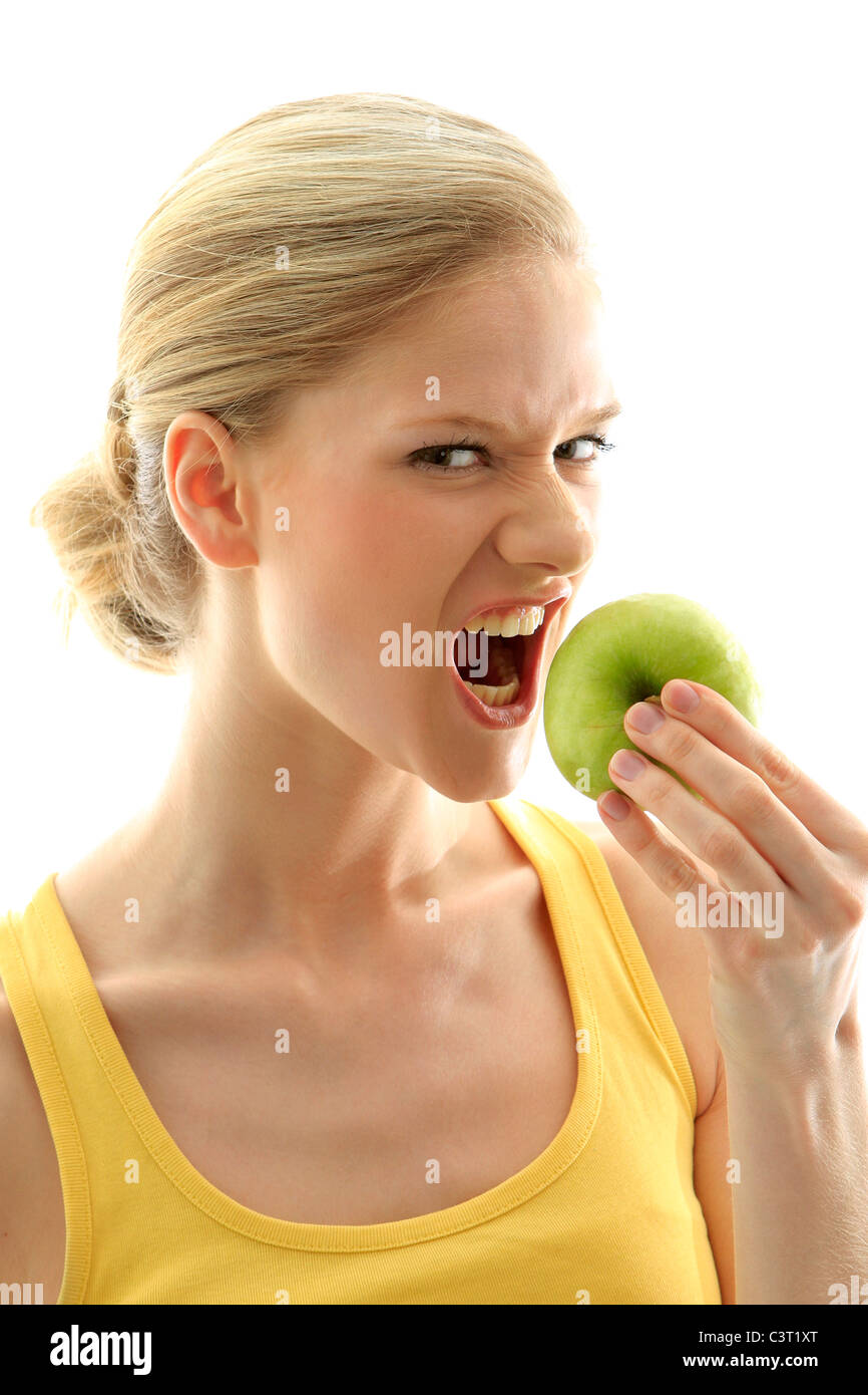 Angry woman with a fresh green apple Stock Photo