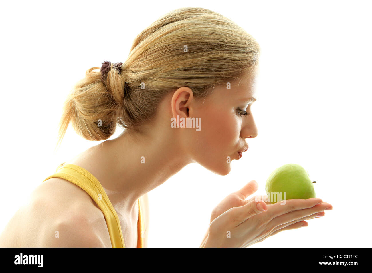 Woman kissing a fresh green apple Stock Photo