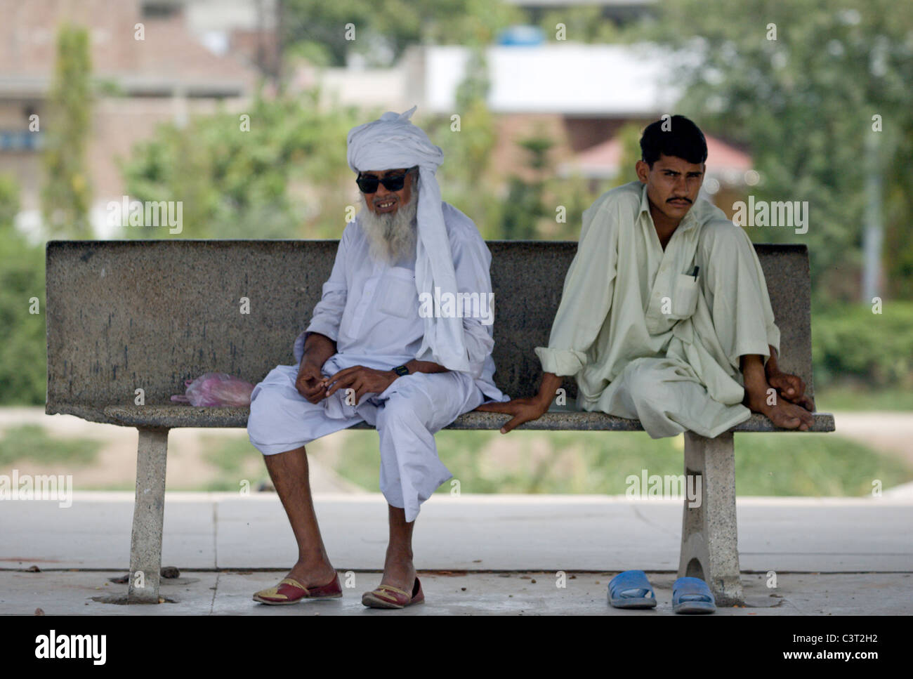 Men sit at a train station near Gujrat Stock Photo
