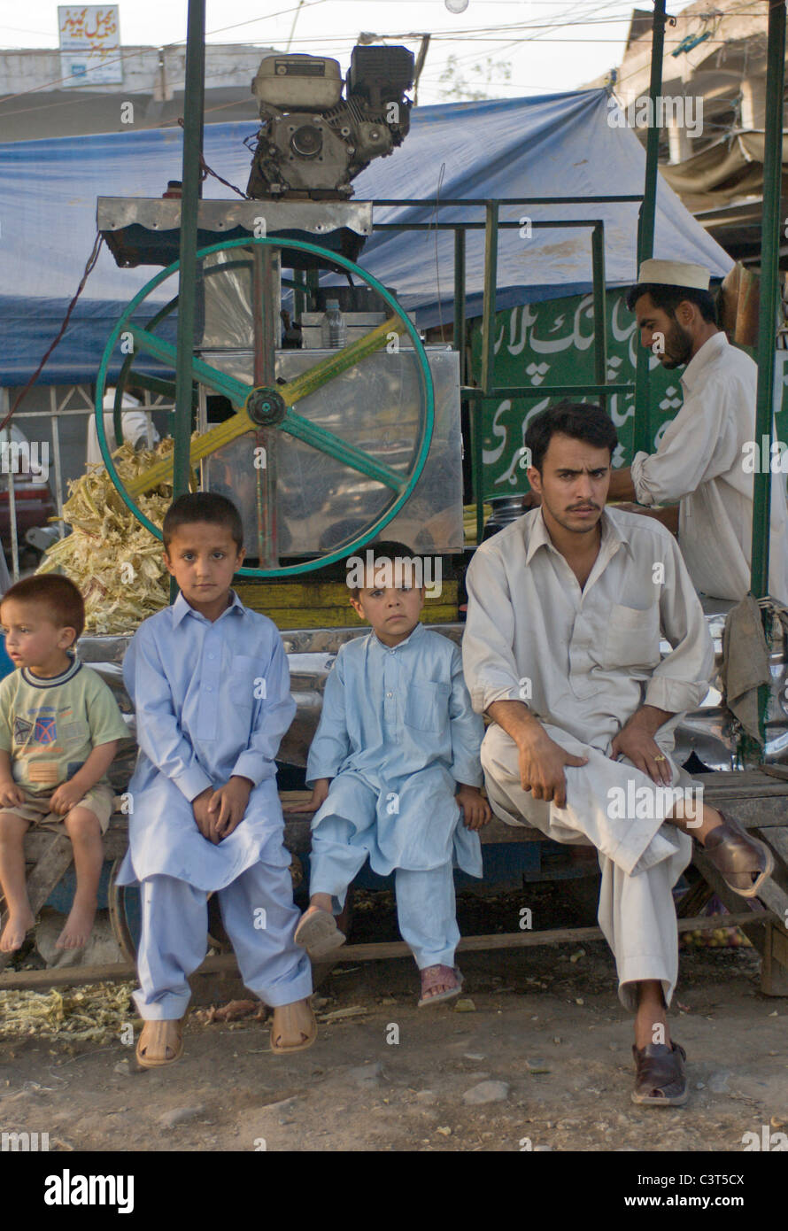 A man and boys sit a a street vendor's stall in the Smugglers' Bazaar. Stock Photo