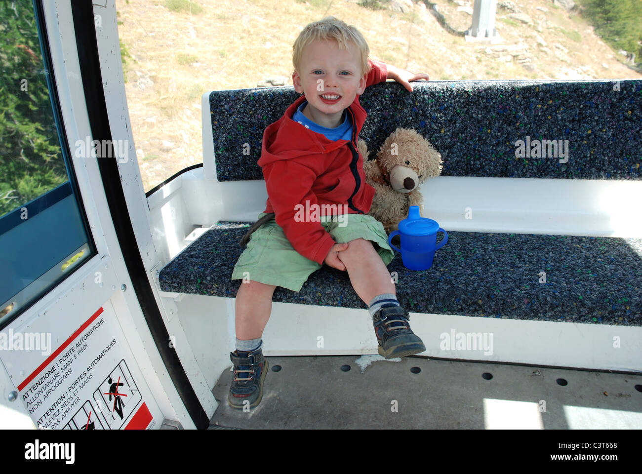 A happy young boy sat in a cable car above Saas Grund, Switzerland. Stock Photo