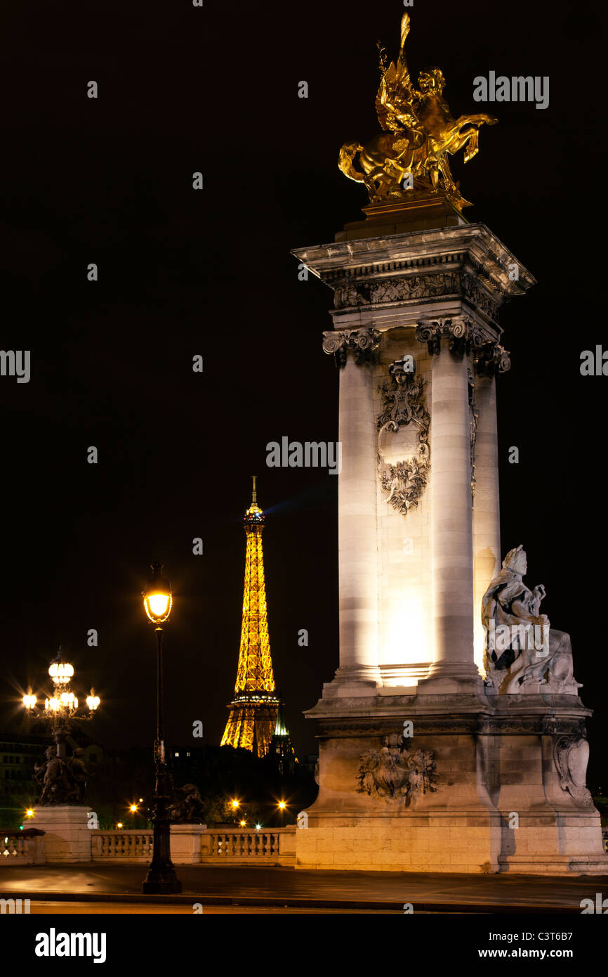Night illumination on the bridge of Alexander III and the Eiffel Tower in Paris. France. Stock Photo