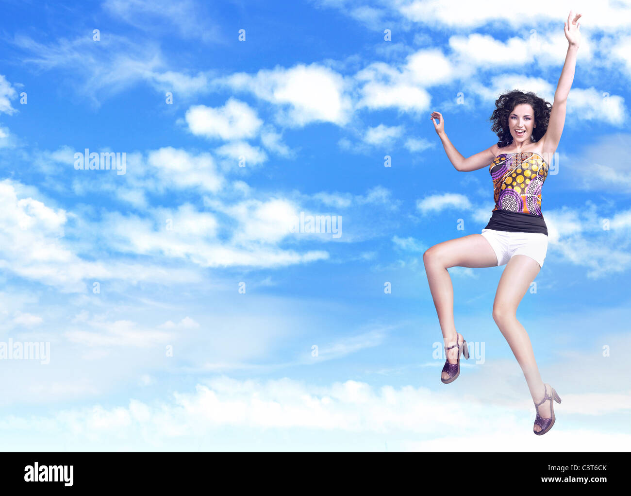 Joyful woman jumping over blue sky background Stock Photo - Alamy