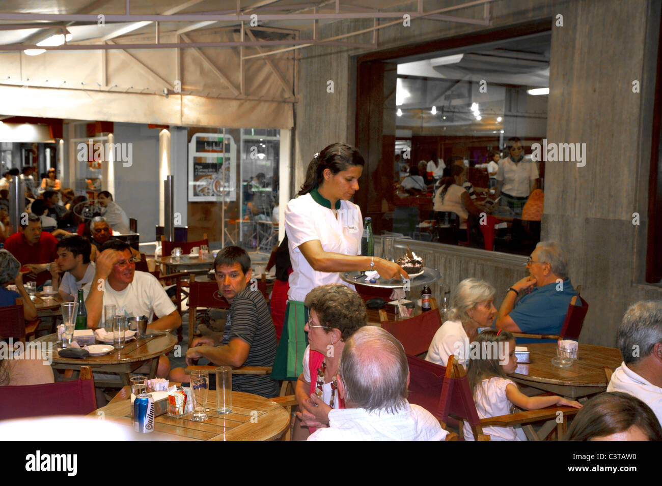 Server with customers in a restaurant at Necochea, Argentina. Stock Photo