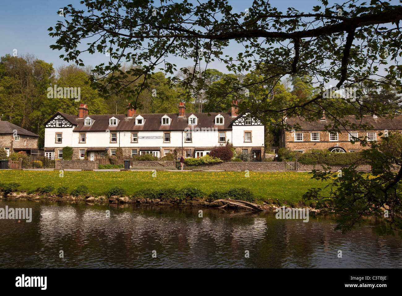 UK, Derbyshire, Peak District, Bakewell, Lumford cottages on banks of River Wye Stock Photo