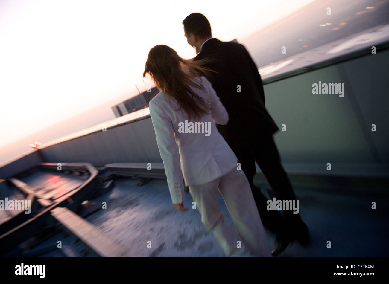A young couple in business attire on a roof, Warsaw, Poland Stock Photo