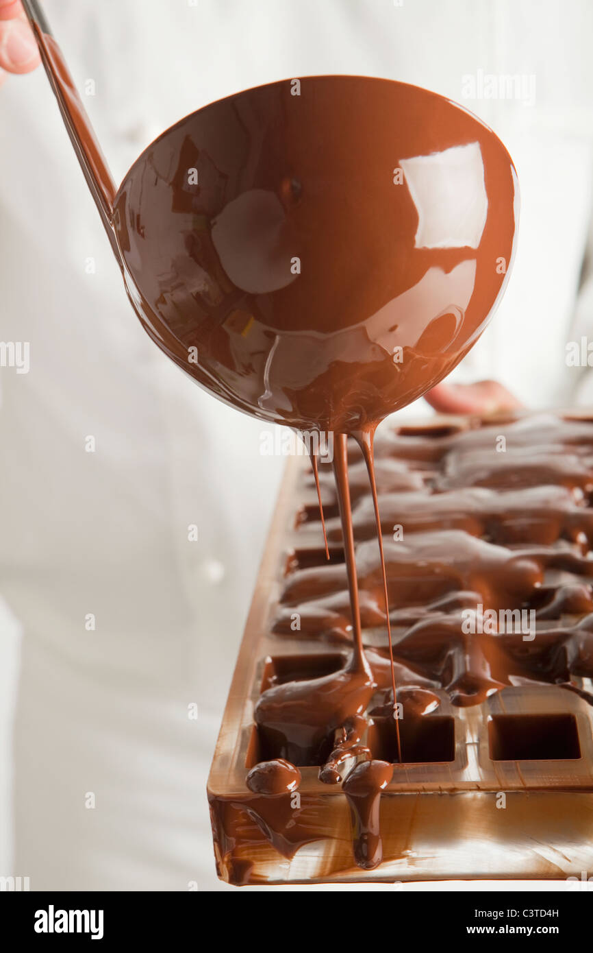 Baker pouring chocolate in mold Stock Photo Alamy