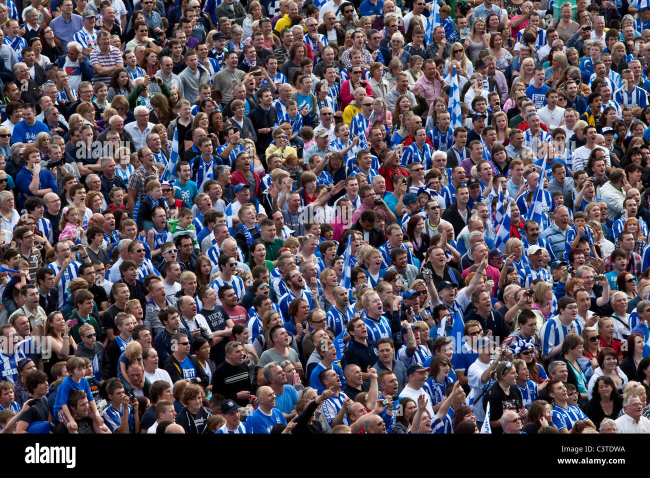 Brighton and Hove Albion Football Supporters cheer the team during the clubs victory parade along Brighton seafront. Stock Photo