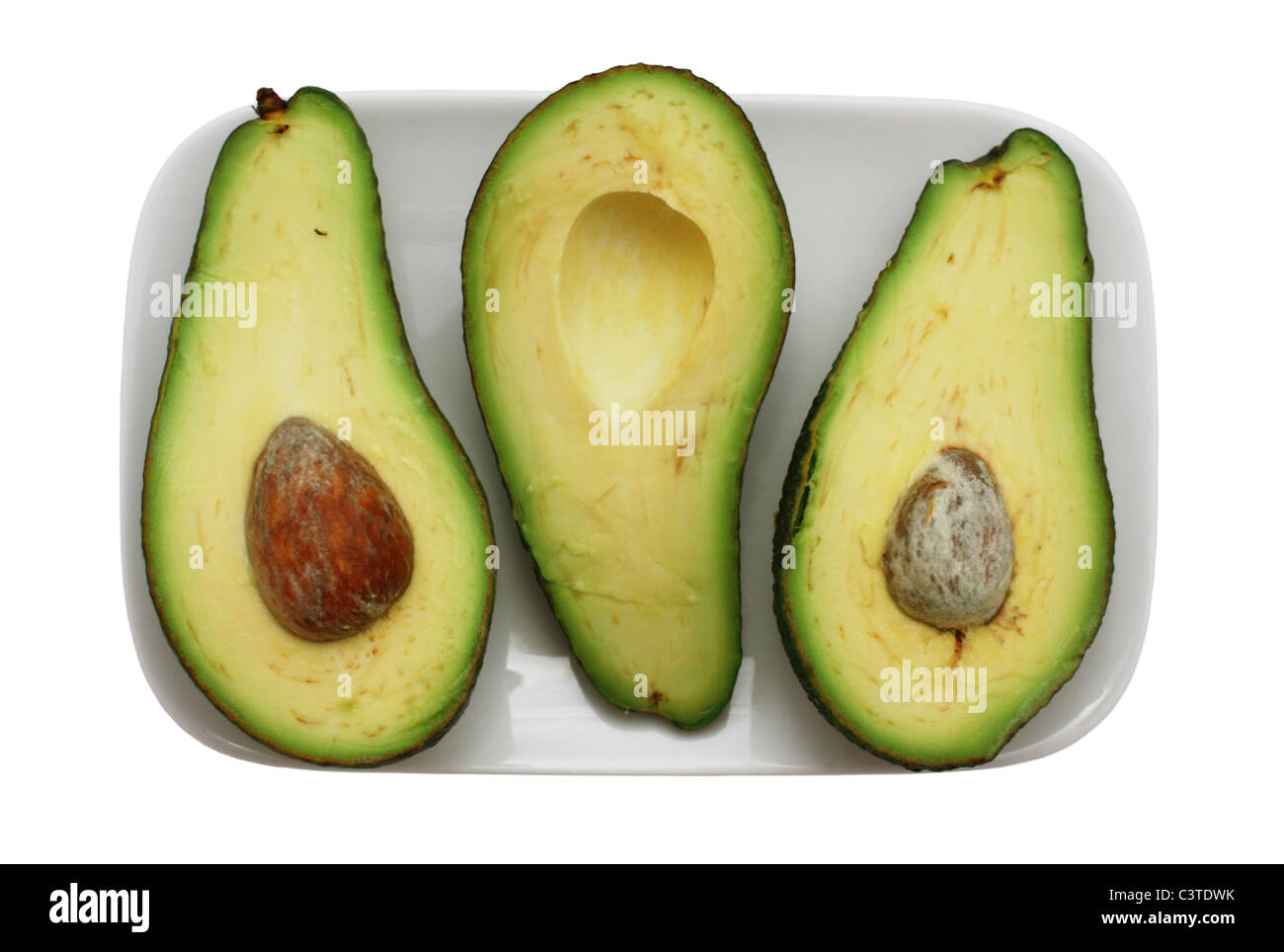 the cut piece avocado on the plate isolated Stock Photo