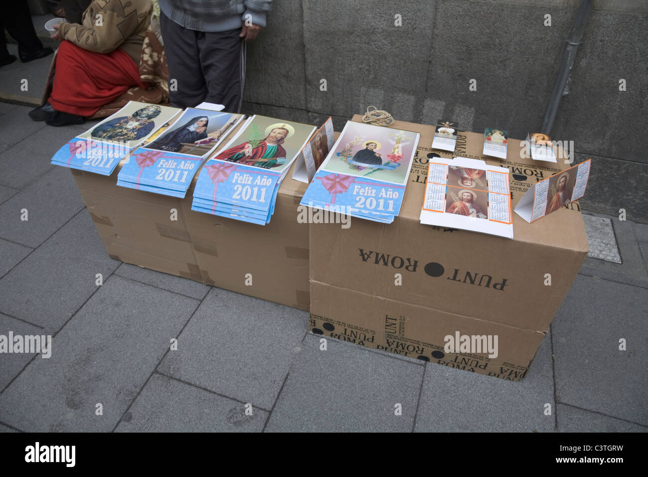 A vendor selling Religious Calendars of Catholic Saints Outside a Church in Madrid , Spain Stock Photo