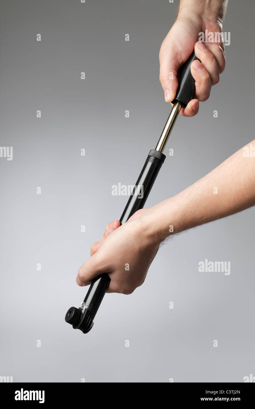 A compact hand-operated black plastic bicycle pump Stock Photo