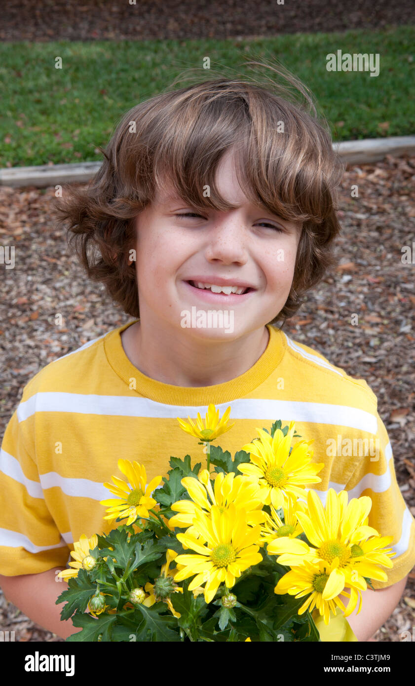 Portrait of 8 year old boy with flowers for mommy Stock Photo Alamy