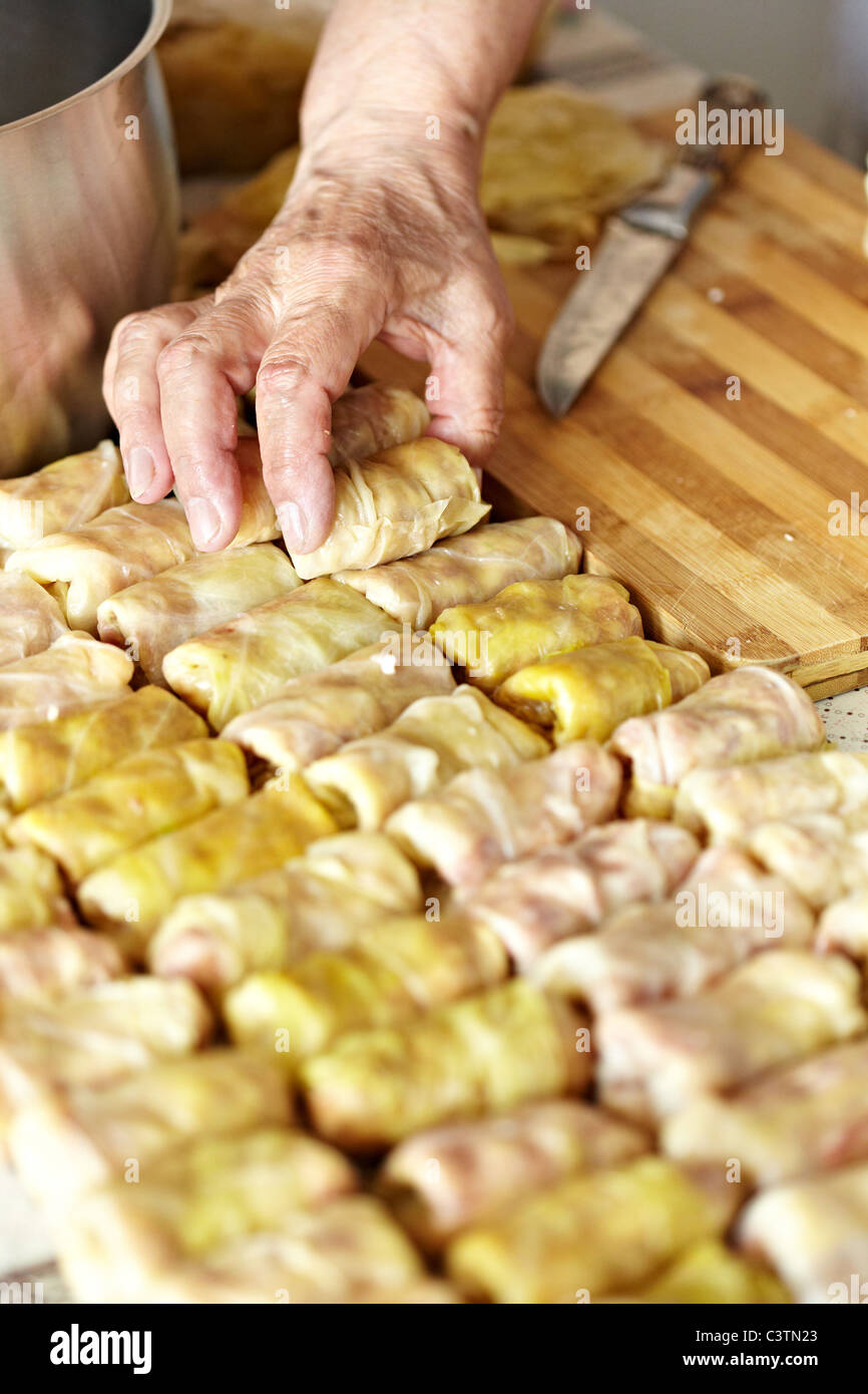 Cooking sarmale, a traditional Romanian dish, with grinded meat and rice wrapped in boiled cabbage leaves Stock Photo