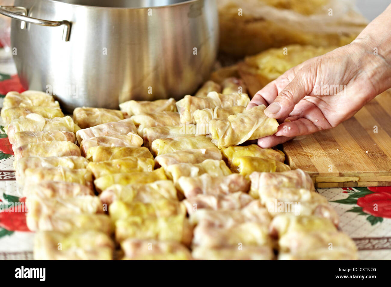 Cooking sarmale, a traditional Romanian dish, with grinded meat and rice wrapped in boiled cabbage leaves Stock Photo