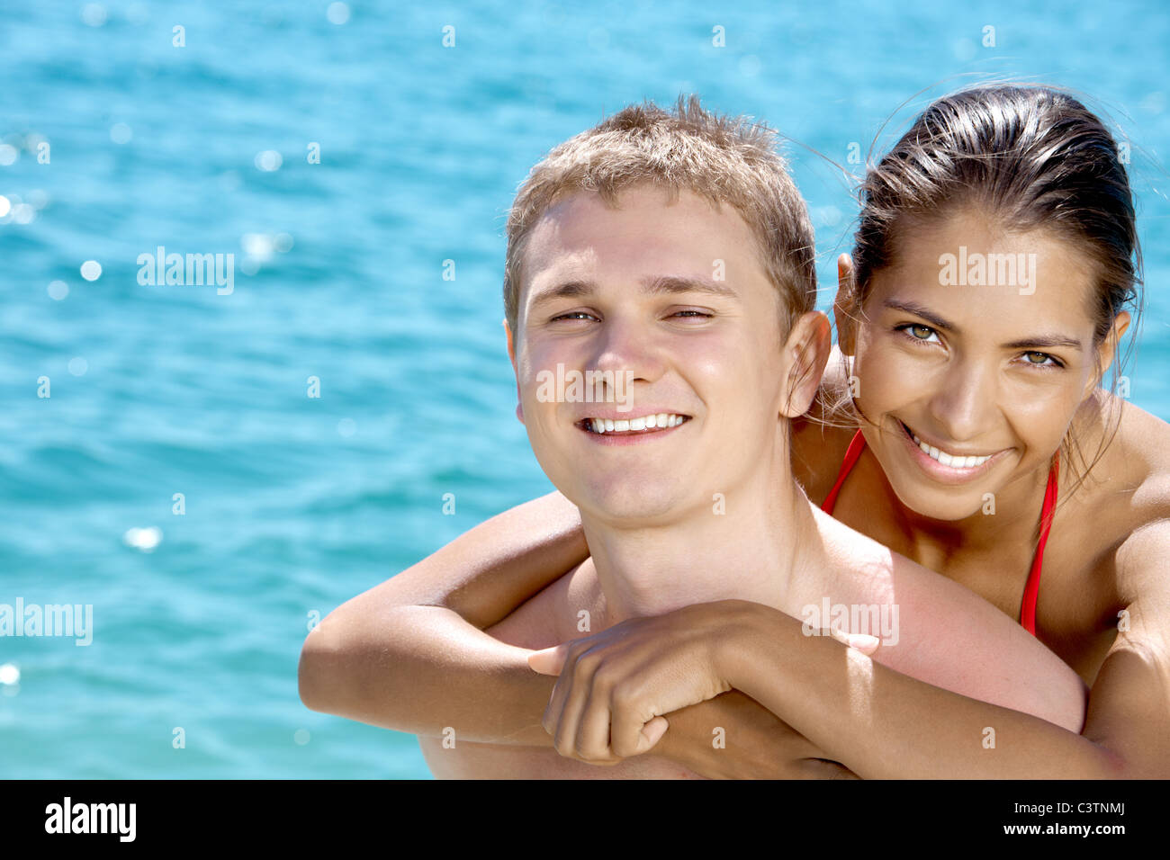 Close-up of smiling girl hugging her boyfriend on the background of ...