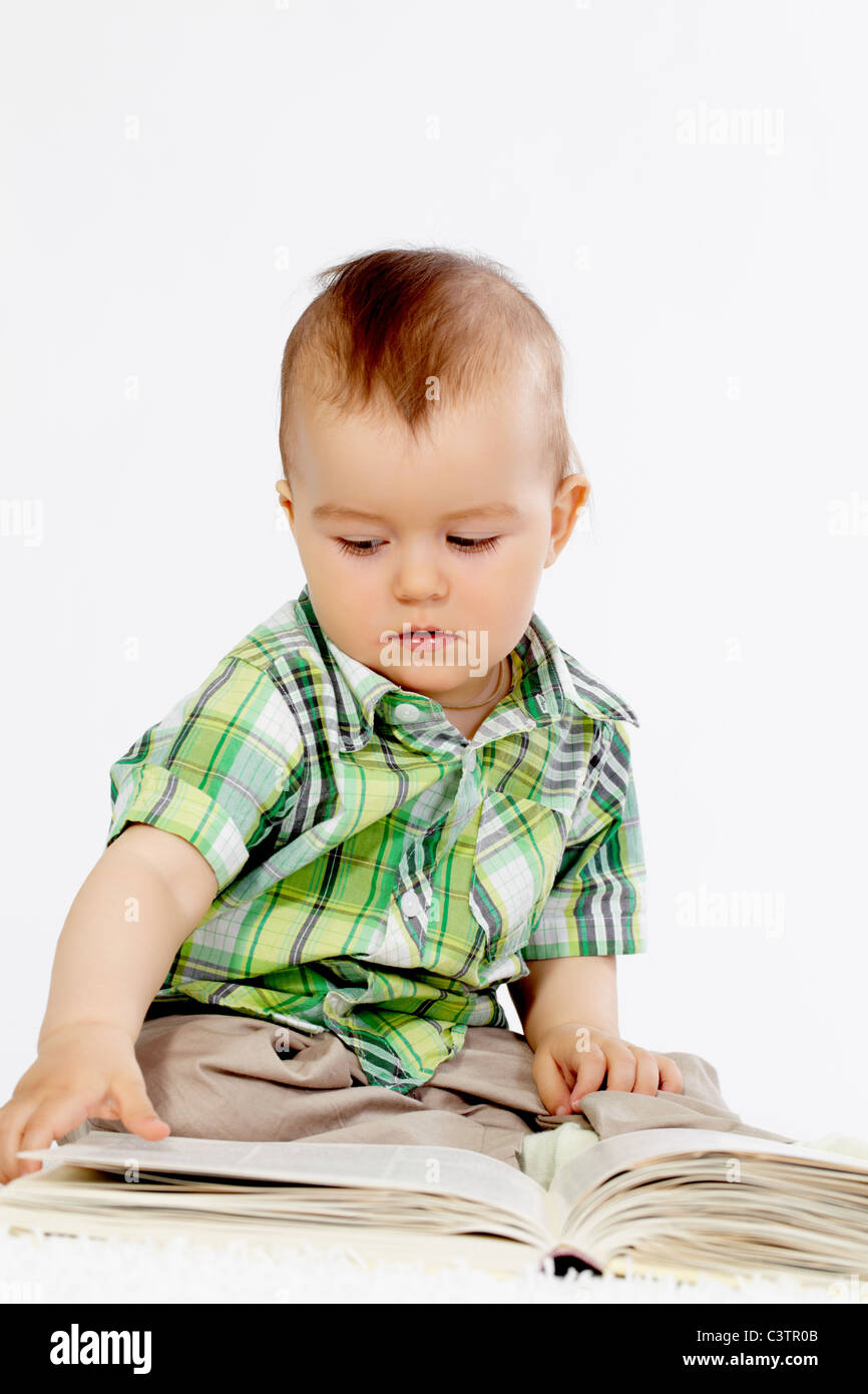 Portrait of baby boy reading book over white background Stock Photo Alamy